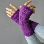 Free Knitting Pattern for Flight of Fancy Mitts. These delicate mitts are knit in the round from the cuff upward. Twist-stitch leaves on a background of reverse stockinette stitch are mirrored on right and left hands.