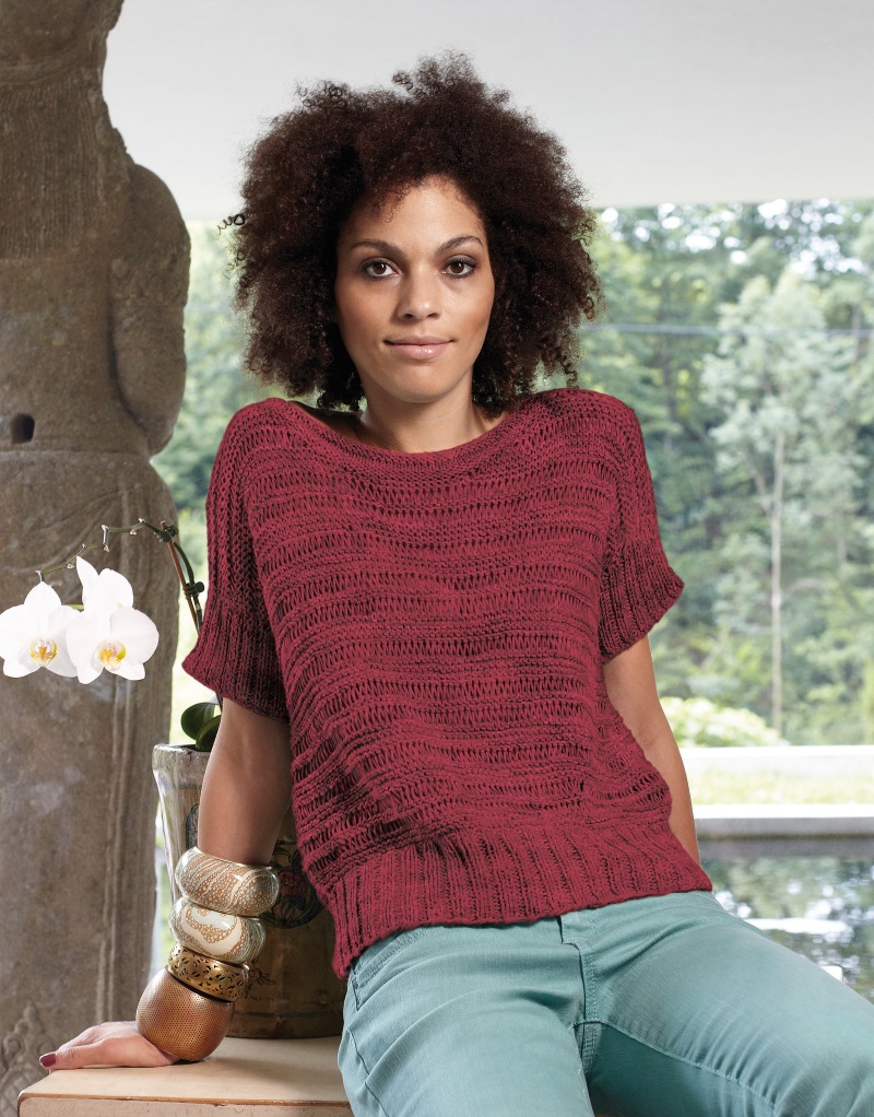 A mix of garter stitch and drop stitches provides the basic pattern for this summery knitted shirt. Wide ribbed bands are knitted on Instead of sleeves, a perfect addition to the high waistband. They also add a casual touch. Sizes XS – XL.