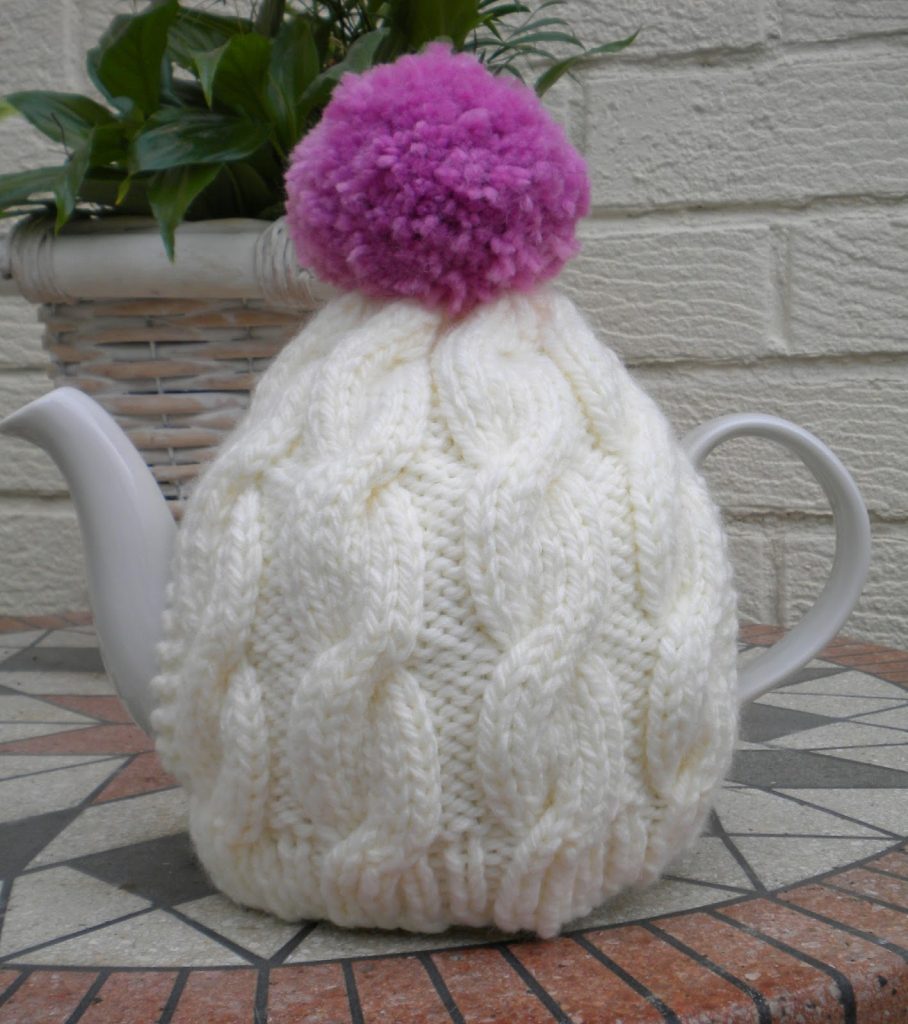 Cabled tea cosy with pom pom